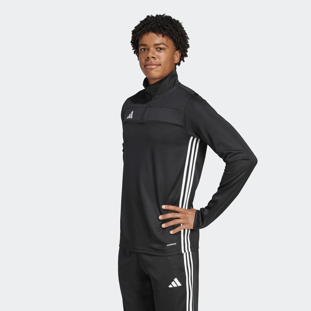 Young man wearing black Adidas Tiro Essentials track top with white stripes and matching pants, front view.