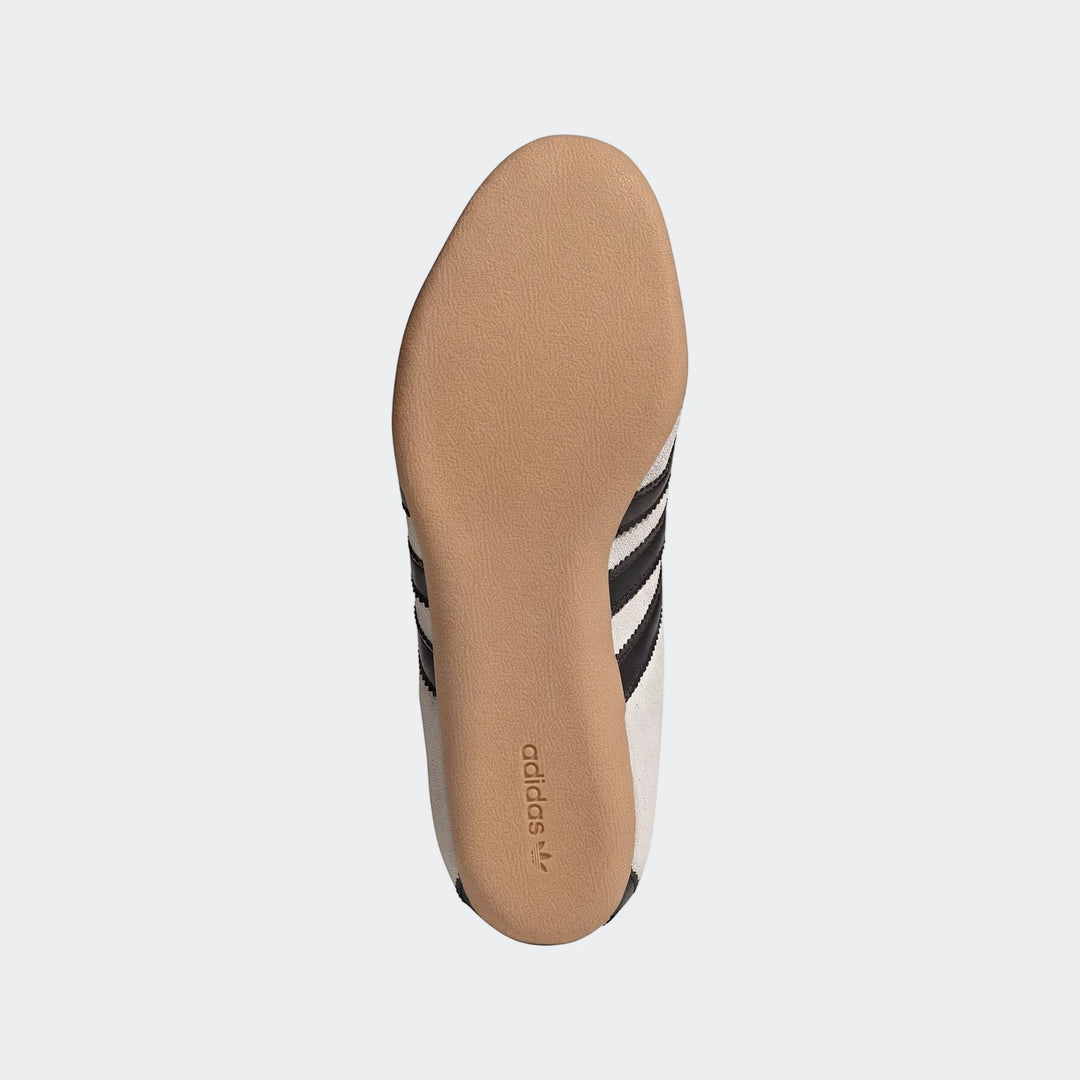 Adidas Tokyo Shoes, sole view, featuring a beige textured sole, white canvas upper, and black stripes with the Adidas logo.