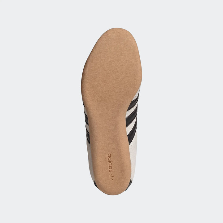 Adidas Tokyo Shoes, sole view, featuring a beige textured sole, white canvas upper, and black stripes with the Adidas logo.