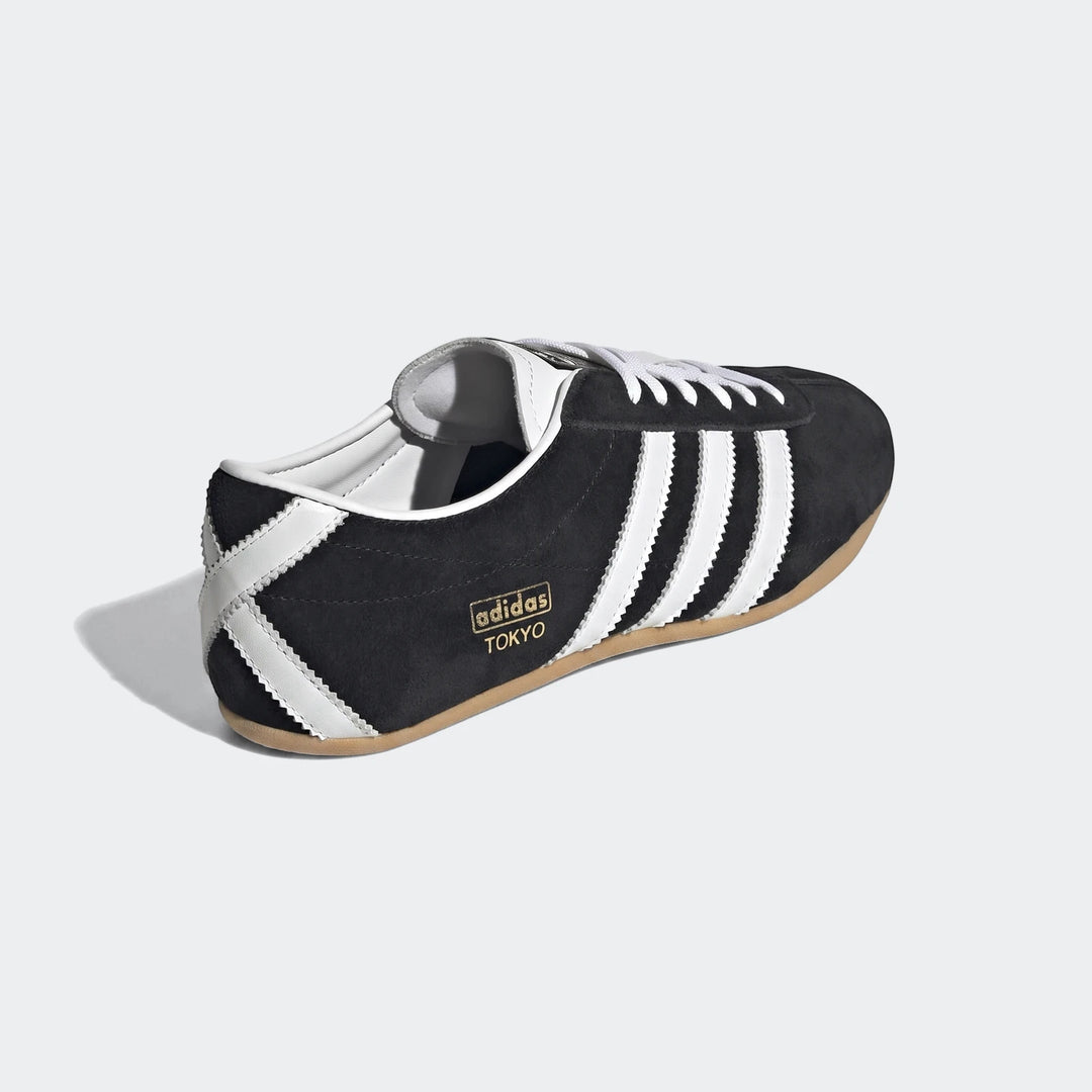 Adidas Tokyo Shoes, black suede upper with white stripes and laces, gold branding, and a gum sole, displayed from a side