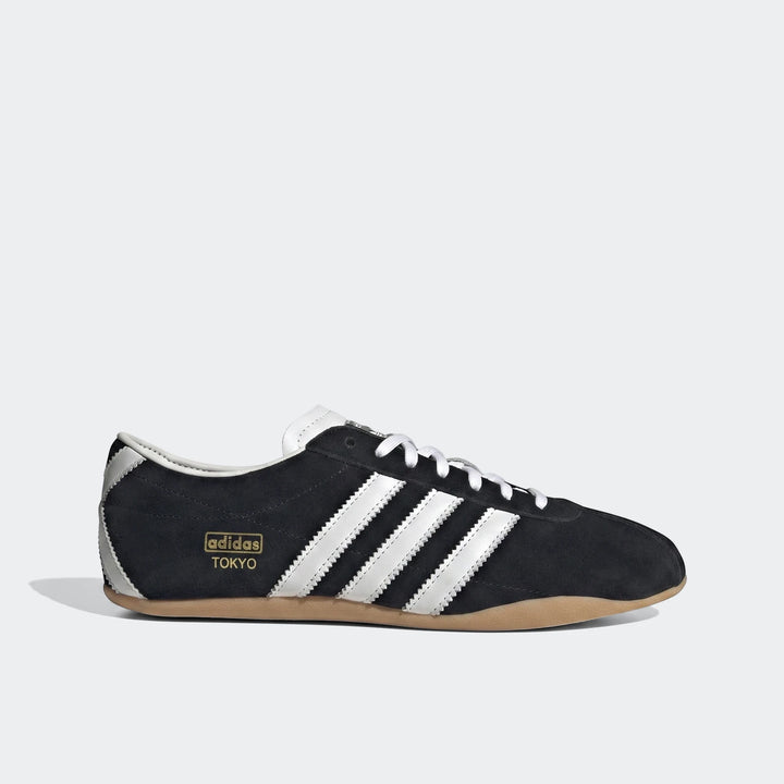 Adidas Tokyo Shoes in black suede with white leather stripes and a light brown gum sole, presented in a side view.