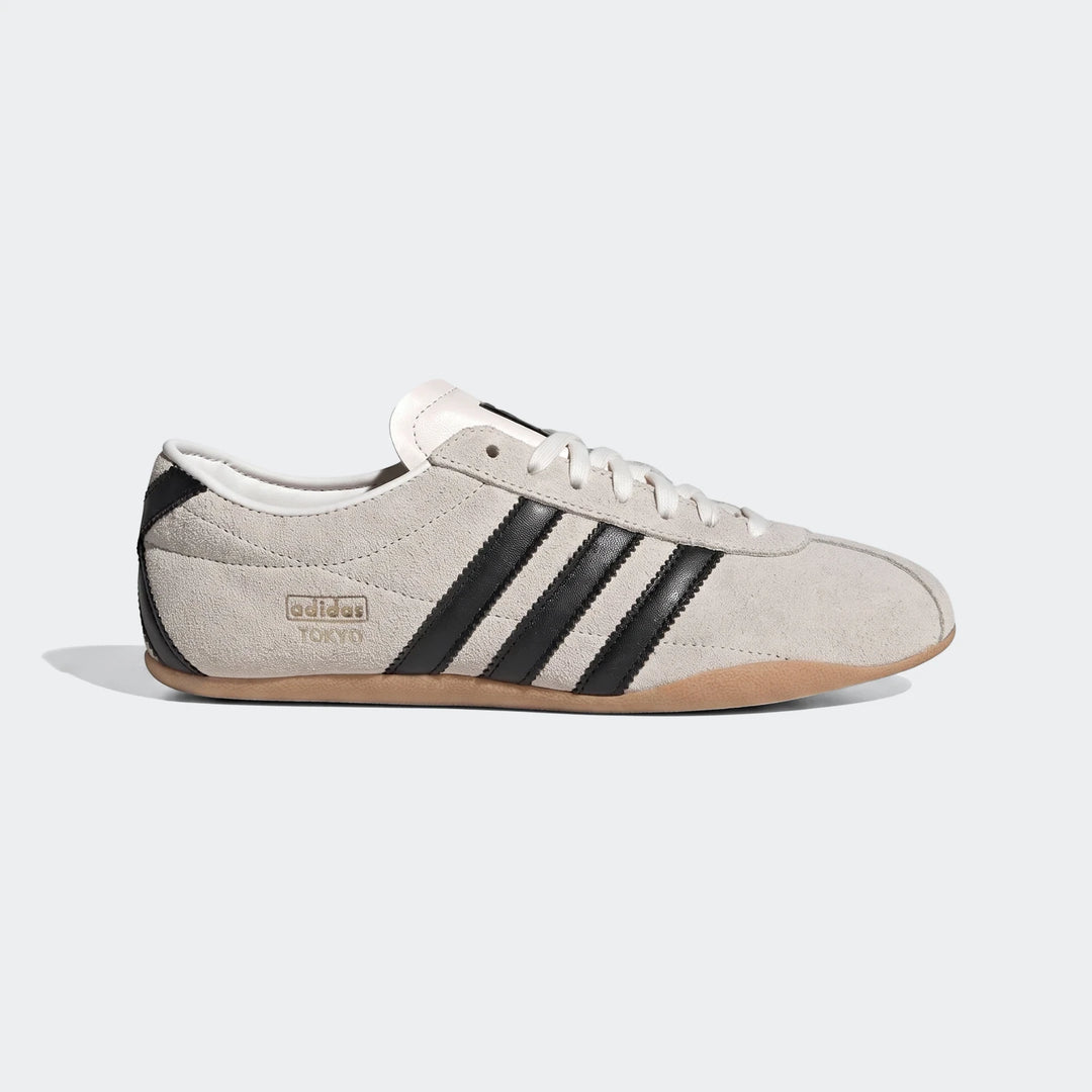 Adidas Tokyo Shoes in light beige suede with black stripes and a brown gum sole, presented in a side view.