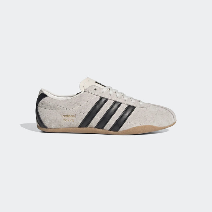 Adidas Tokyo shoes in light grey suede with black stripes and tan gum sole, shown from a side view.