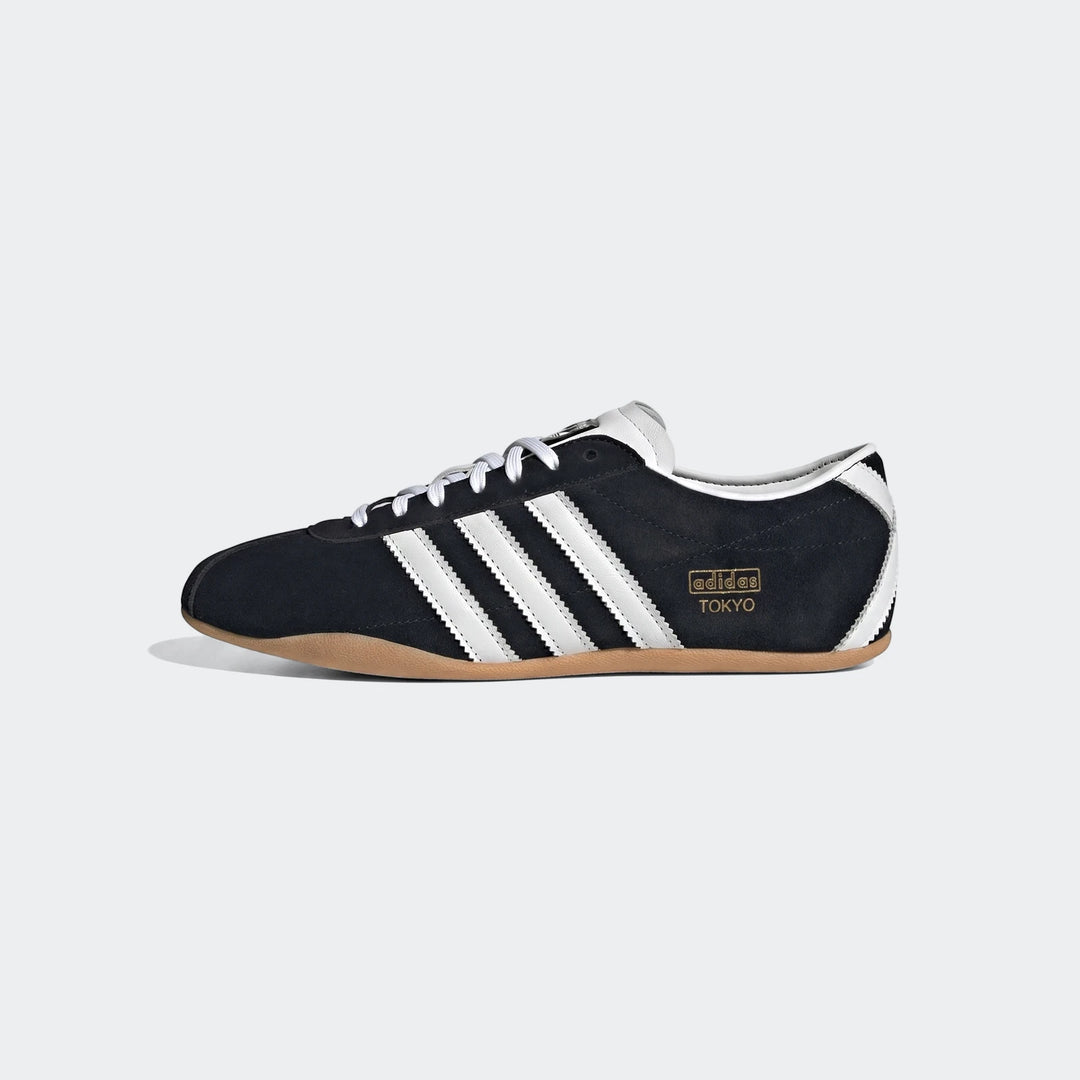 Black and white Adidas Tokyo sneakers, featuring suede upper, iconic white stripes, and a distinctive gum sole, viewed from