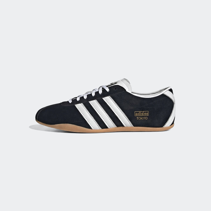 Black and white Adidas Tokyo sneakers, featuring suede upper, iconic white stripes, and a distinctive gum sole, viewed from