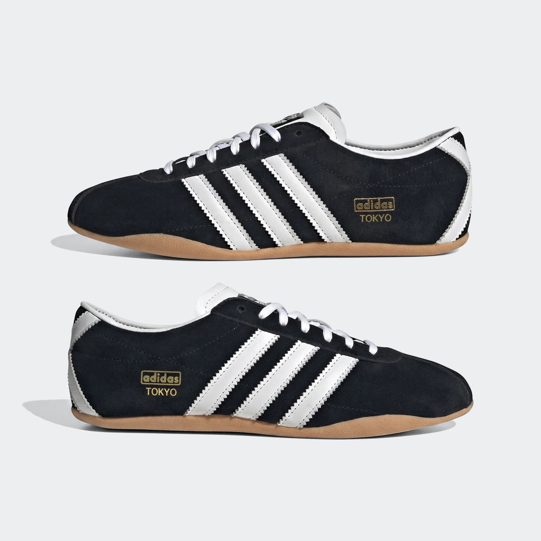 Black suede Adidas Tokyo sneakers with white leather stripes, white laces, and gum rubber soles, shown from a side profile.