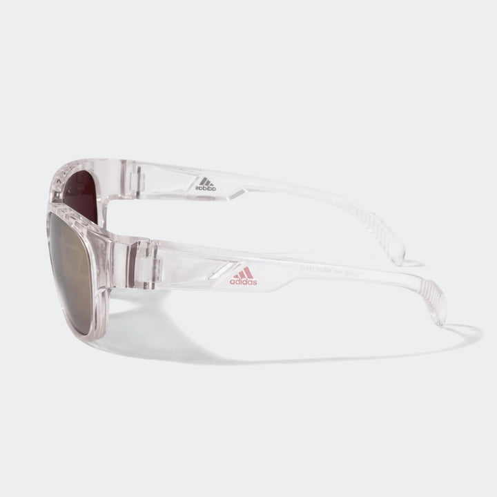 Adidas Transparent Sunglasses featuring a clear frame and brown lenses, showcasing the iconic logo on the side in a stylish