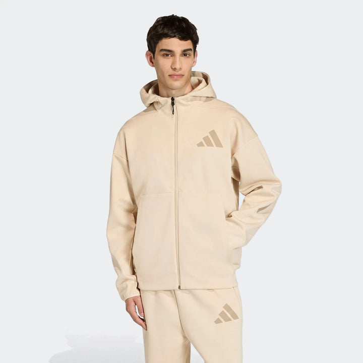 Beige Adidas Z.N.E. full-zip hoodie and matching sweatpants on a male model, three-quarter view.