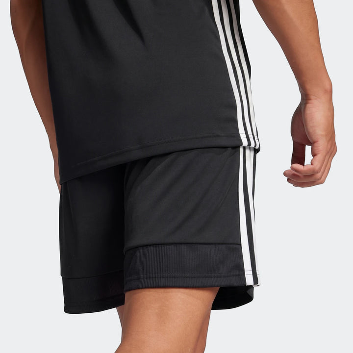 Person wearing a black Adidas Z.N.E. Track Top and matching black shorts with white three-stripe detailing, viewed from the