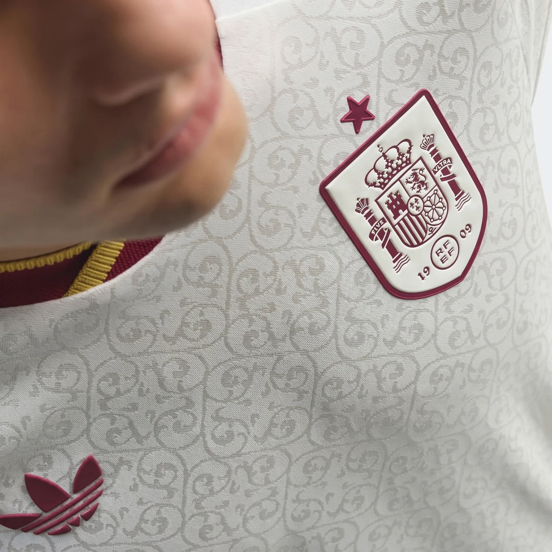 Close-up of a white Adidas Z.N.E. Track Top, featuring the Spain national team crest and Adidas Trefoil logo, worn by a