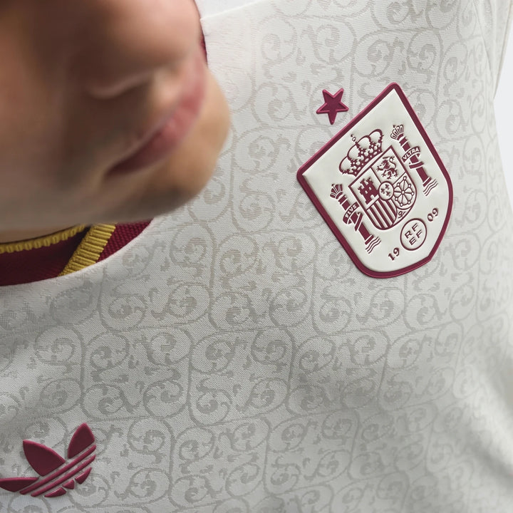 Close-up of a white Adidas Z.N.E. Track Top, featuring the Spain national team crest and Adidas Trefoil logo, worn by a