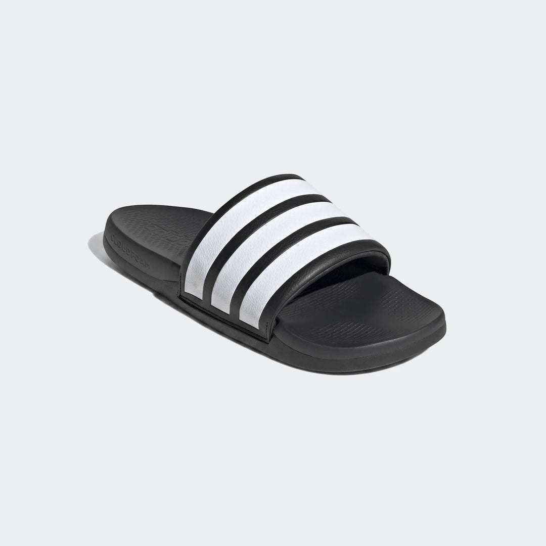 Black Adilette Comfort 2.0 slides with iconic white stripes, viewed from a slightly elevated angle.