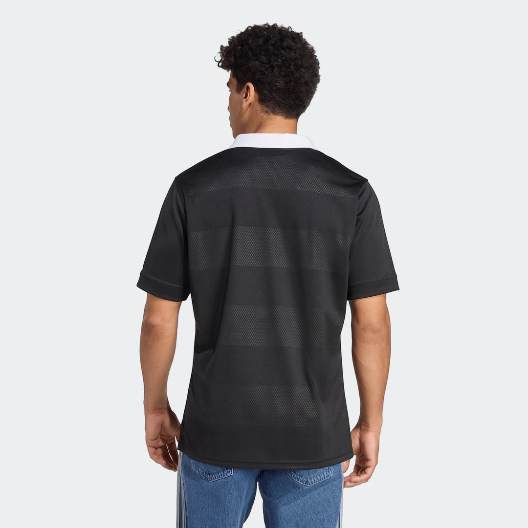 Rear view of a man wearing a black All Blacks Home Jersey with a white collar and horizontal textured stripes.