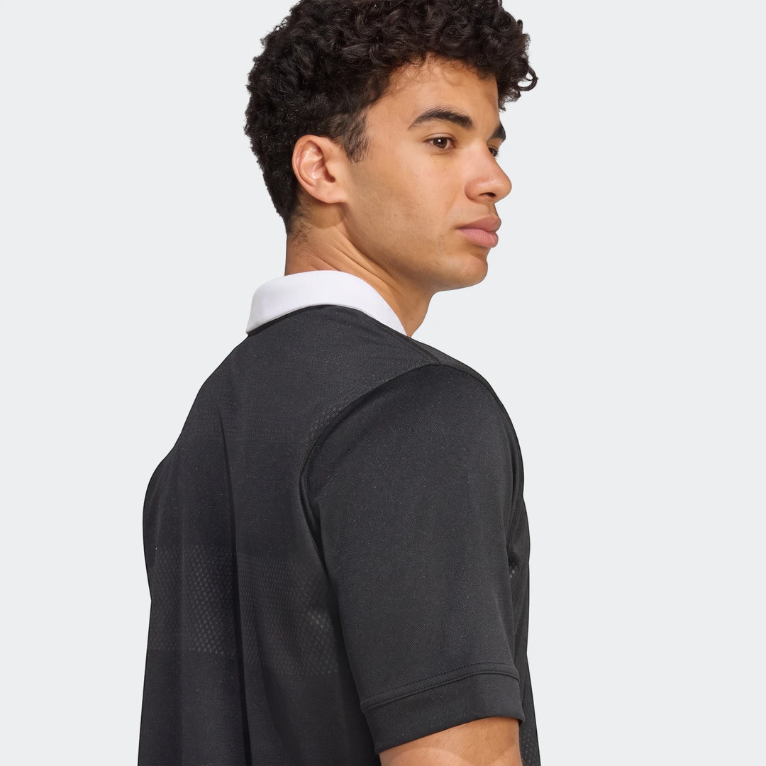 Male model in black All Blacks Home Jersey with white collar, shown from the waist up in profile.