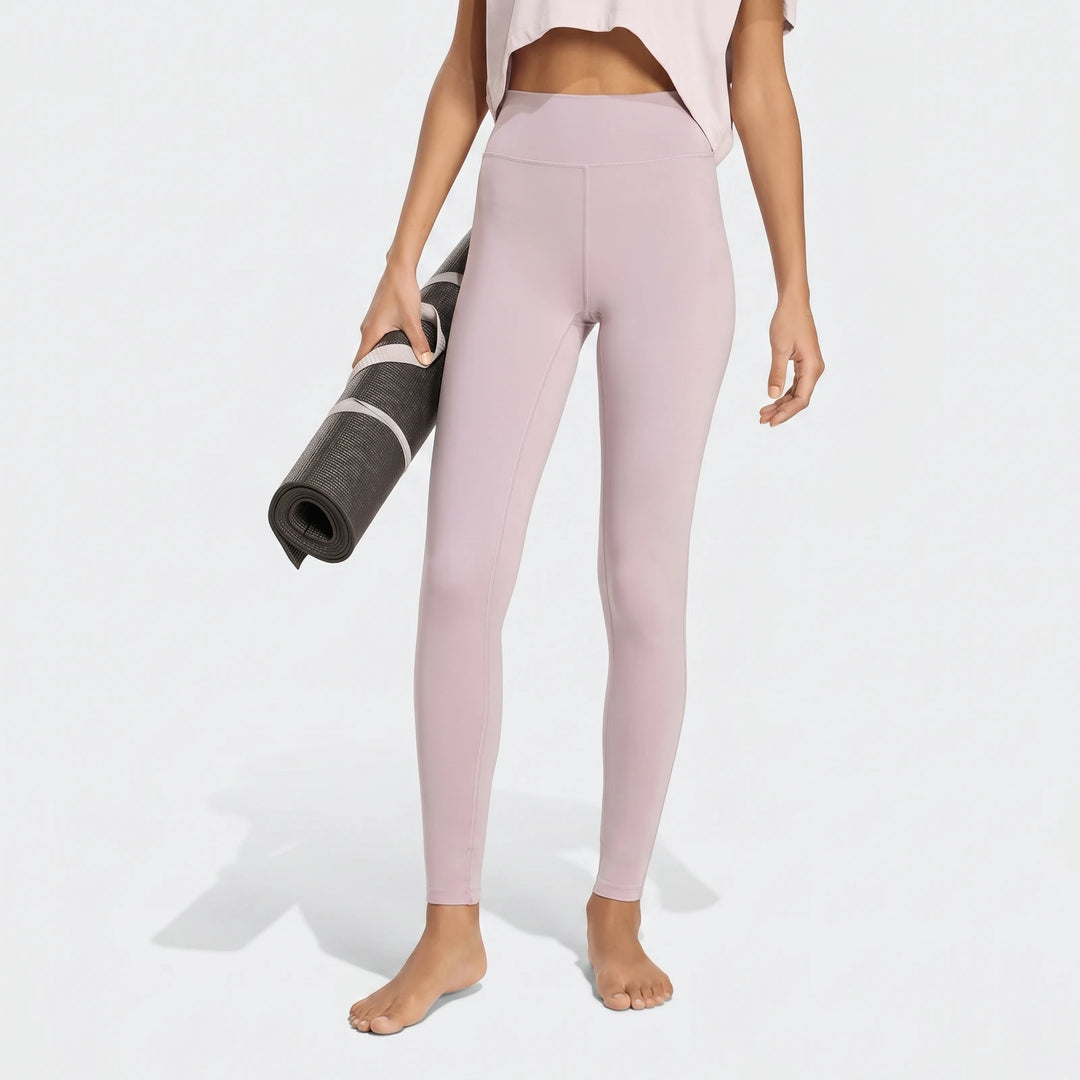 Person in light purple All Me Essentials Full-Length Tights holding a yoga mat, shown from waist to feet.