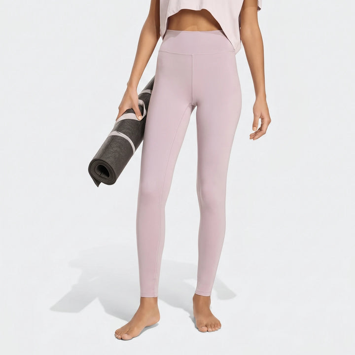 Person in light purple All Me Essentials Full-Length Tights holding a yoga mat, shown from waist to feet.