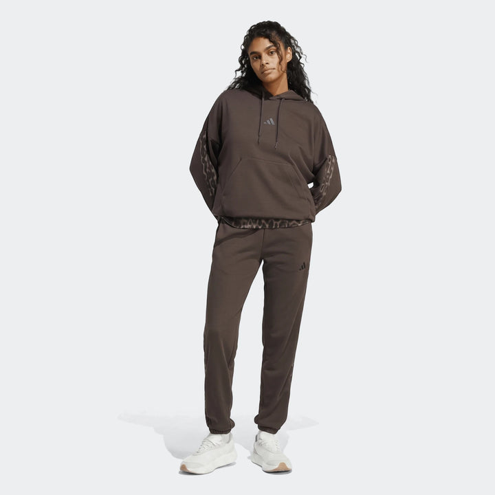Brown All-Over Print Infill French Terry Hoodie with leopard print details worn by a female model, paired with matching