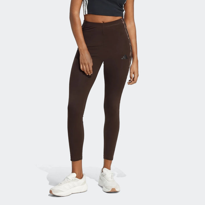 Brown All-Over Print Infill Leggings for women, featuring a subtle pattern and Adidas logo, styled with white sneakers.