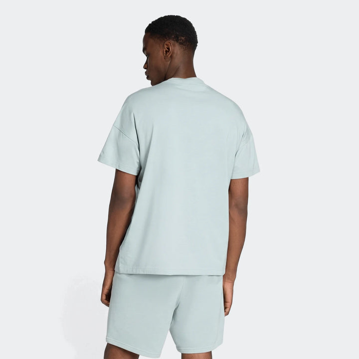 Male model wearing a light blue All Season T-Shirt and matching shorts, seen from the back with an oversized fit.