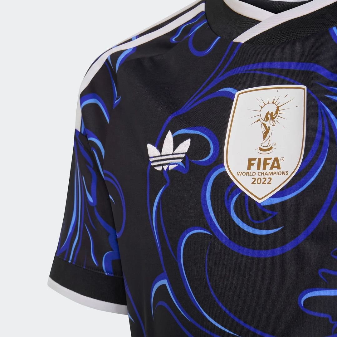 Close-up view of the Argentina 25/26 Away Jersey Youth in black with blue patterns, featuring white Adidas branding and the