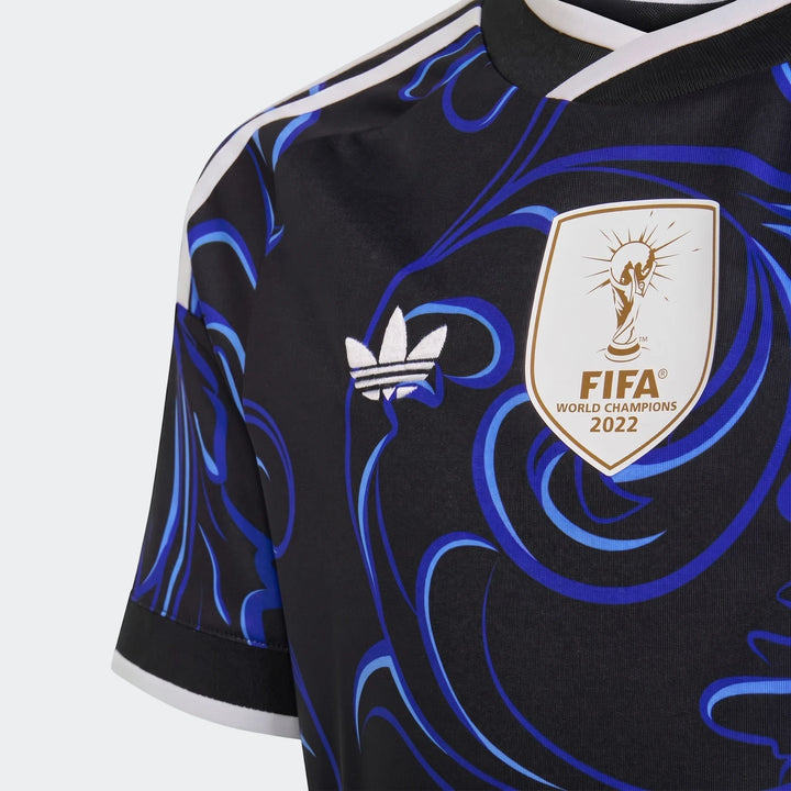 Close-up view of the Argentina 25/26 Away Jersey Youth in black with blue patterns, featuring white Adidas branding and the