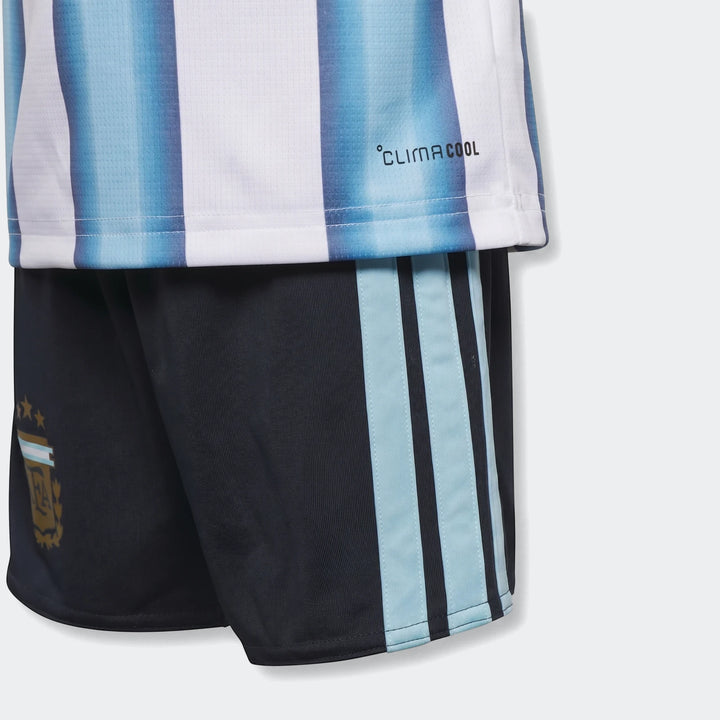 Close-up of an Argentina 26 Home Kids Set featuring a blue and white striped jersey and dark blue shorts with logo.