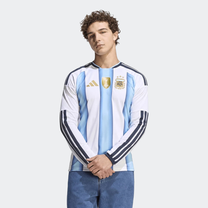Male model wearing the official Argentina 26 Home Long Sleeve Jersey, showcasing its white and light blue striped design,