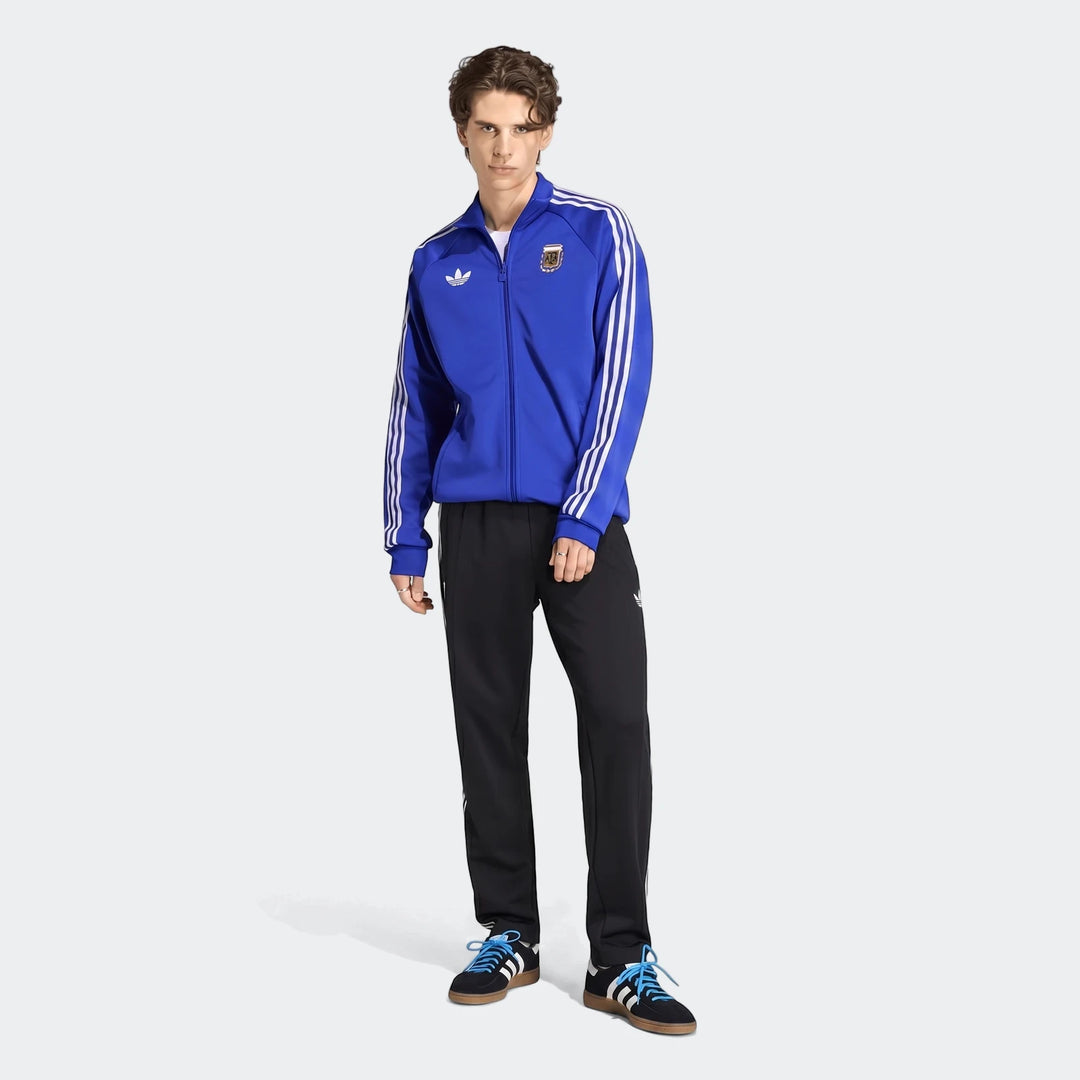 Blue Adidas Argentina Originals Track Top on a male model, paired with black track pants, in a full body shot.
