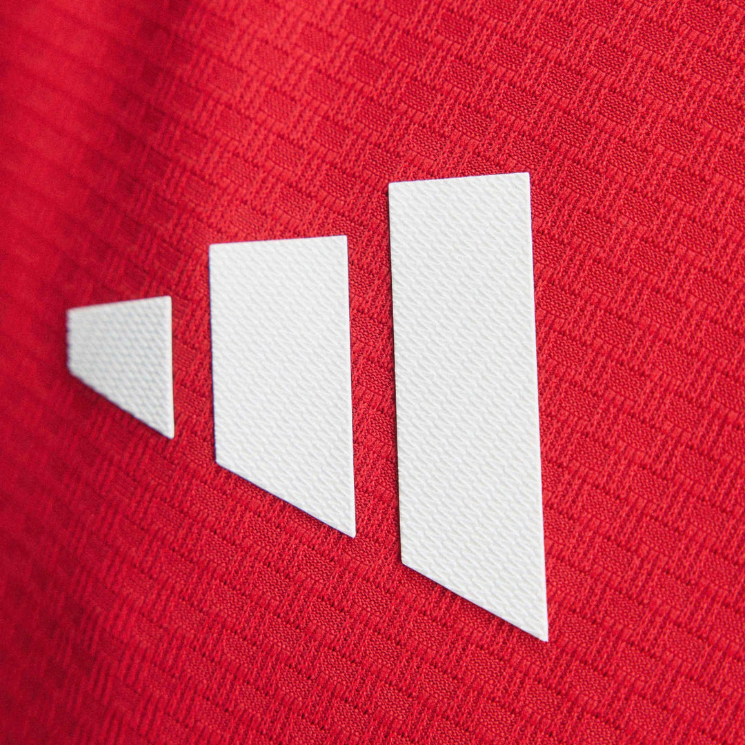 Close-up of Arsenal Fc 26/27 Home Authentic Jersey showing the red textured fabric and white abstract stripes logo.