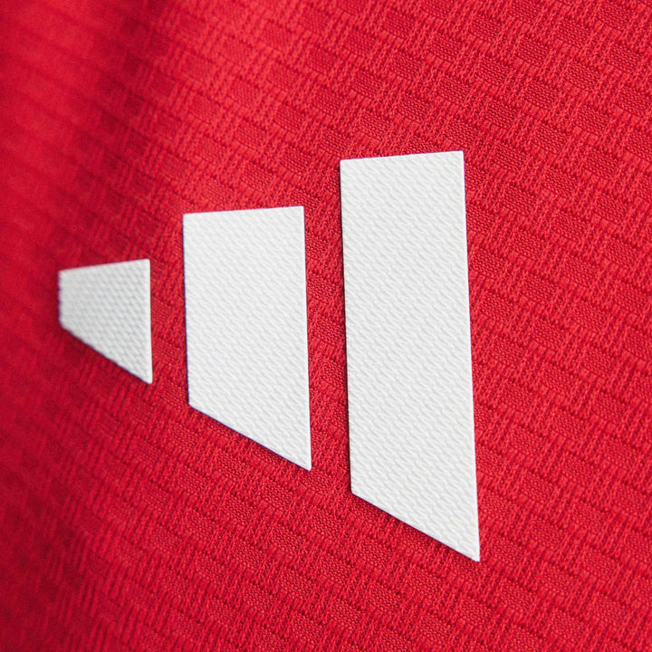 Close-up of Arsenal Fc 26/27 Home Authentic Jersey showing the red textured fabric and white abstract stripes logo.