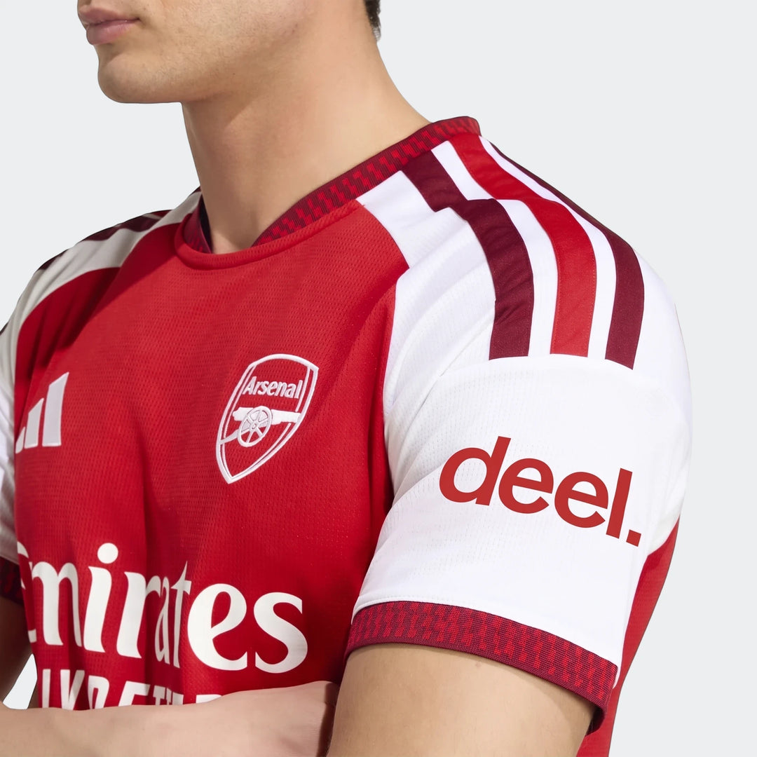 Close-up of a male model wearing the Arsenal FC 26/27 Home Jersey, featuring red and white design, team crest, and sponsor