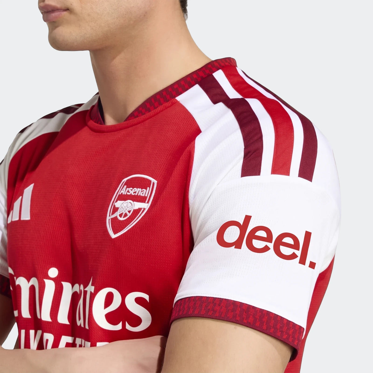 Close-up of a male model wearing the Arsenal FC 26/27 Home Jersey, featuring red and white design, team crest, and sponsor