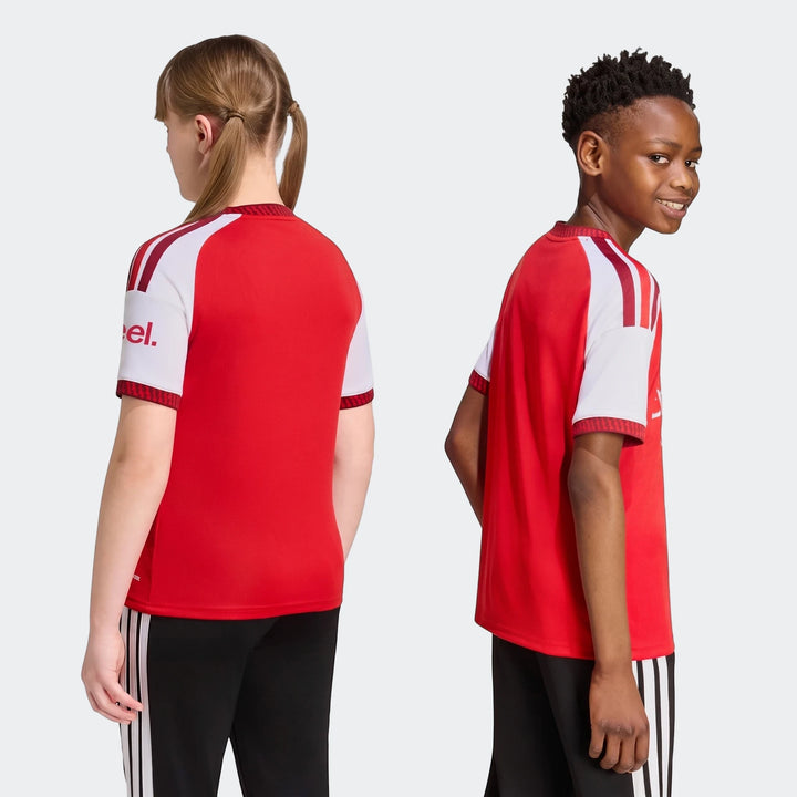 Red and white Arsenal Fc 26/27 Home Kids Jersey worn by a girl and a boy, shown from back and side views.
