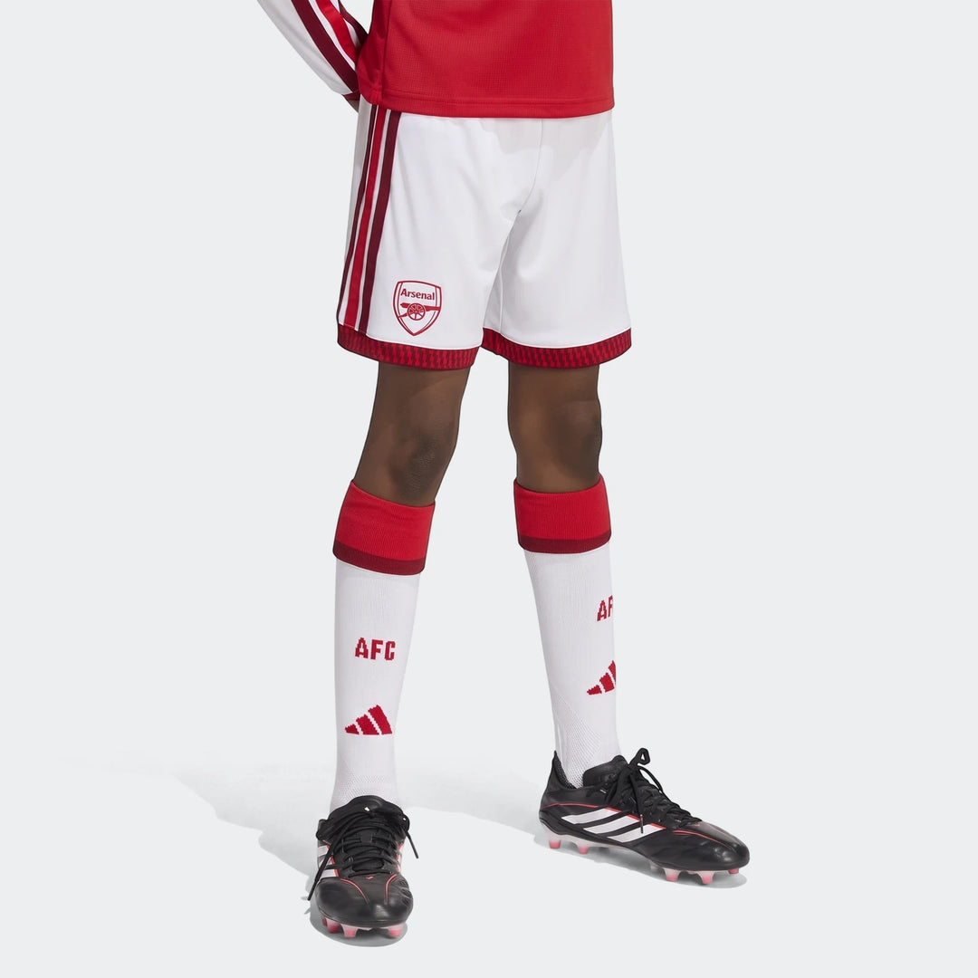 Arsenal FC 26/27 Home Kids Shorts in white with red details, worn by a child in a complete football uniform including socks