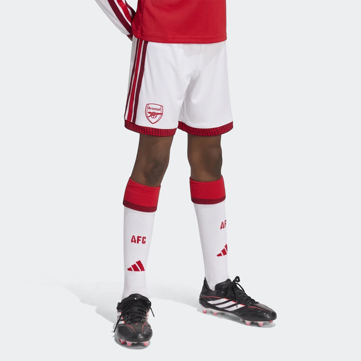 Arsenal FC 26/27 Home Kids Shorts in white with red details, worn by a child in a complete football uniform including socks