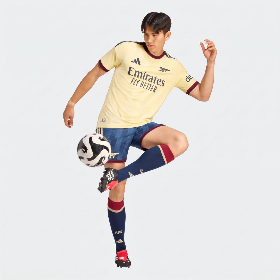 Male model in Arsenal Fc 26/27 Third Authentic Jersey, yellow, blue shorts, and matching kit, juggling a soccer ball.