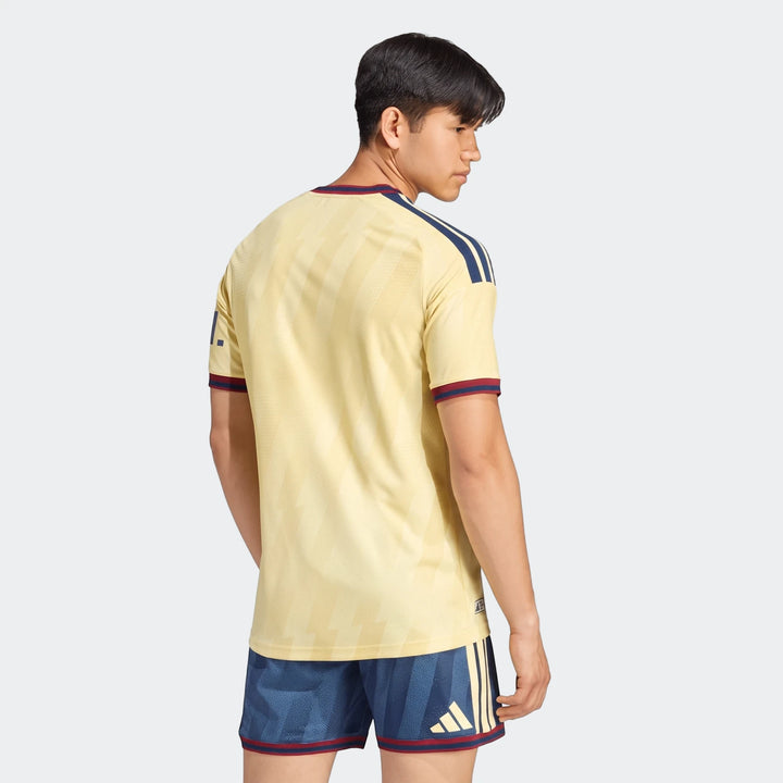 Male model wearing the Arsenal FC 26/27 Third Authentic Jersey in yellow and matching navy shorts, viewed from the back and