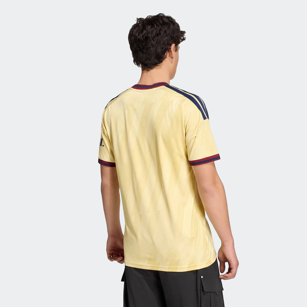 Arsenal Fc 26/27 Third Jersey in yellow with blue and red accents, modeled from the back, paired with black cargo shorts.