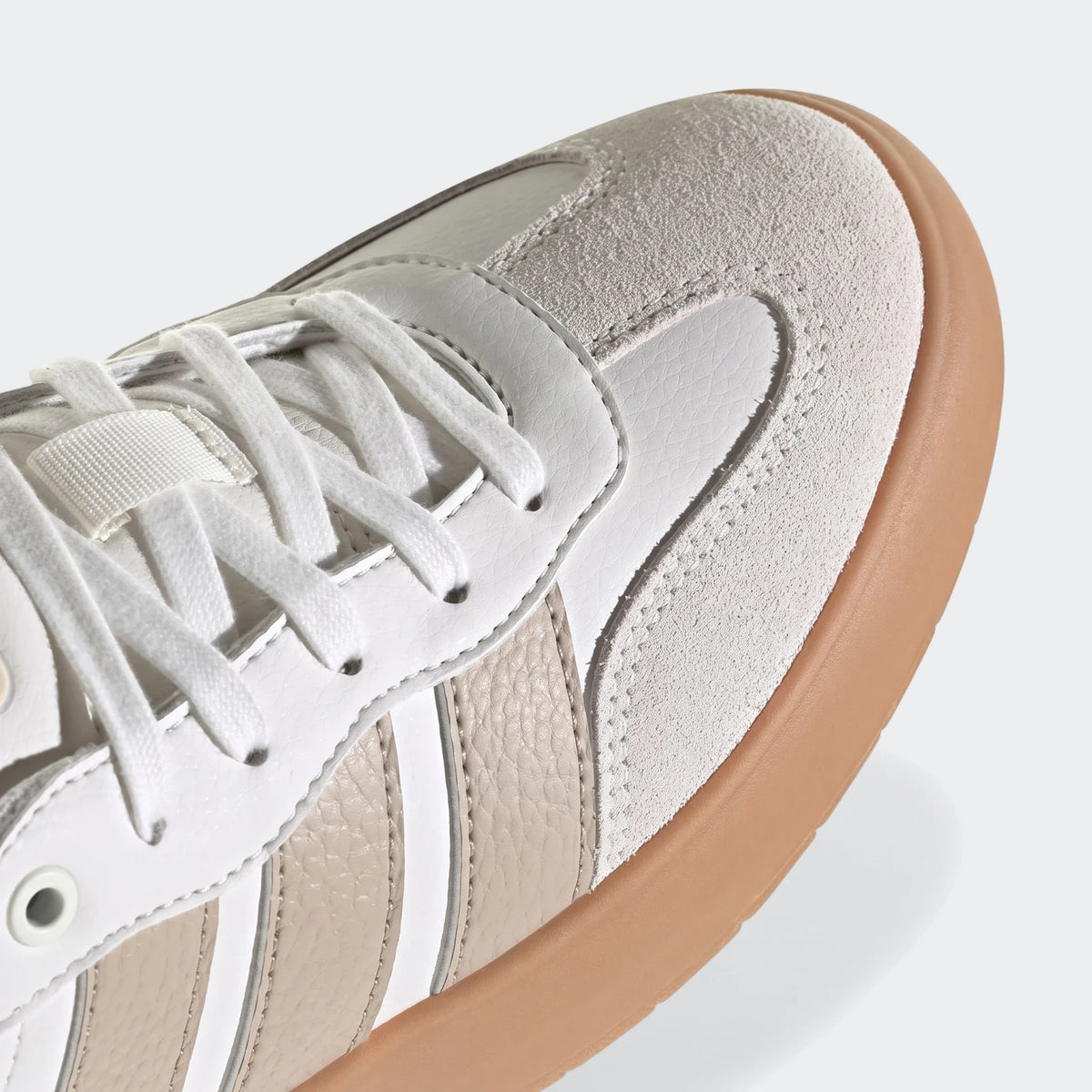 Close-up of a Barreda shoe featuring white and beige panels, white laces, and a brown gum sole.