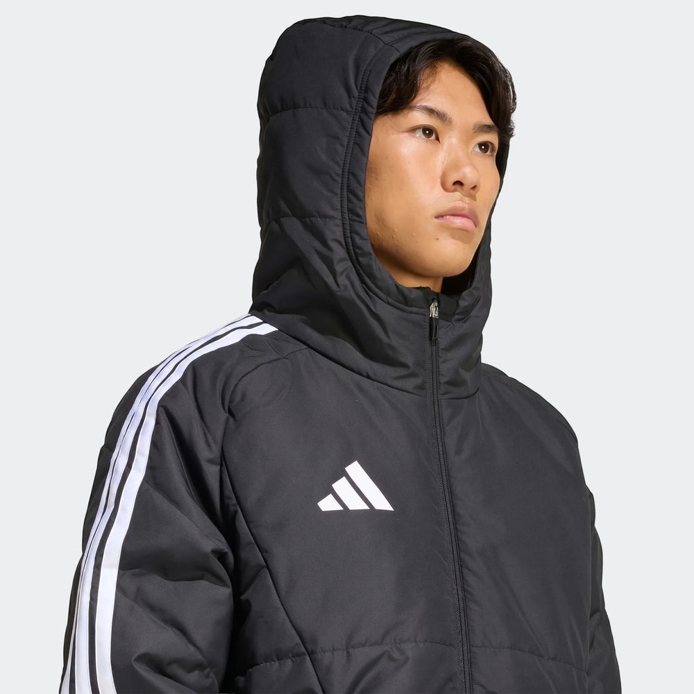 Close-up of a male model wearing a black Adidas Tiro 26 Windbreaker Jacket with a hood and white stripes on the arm.