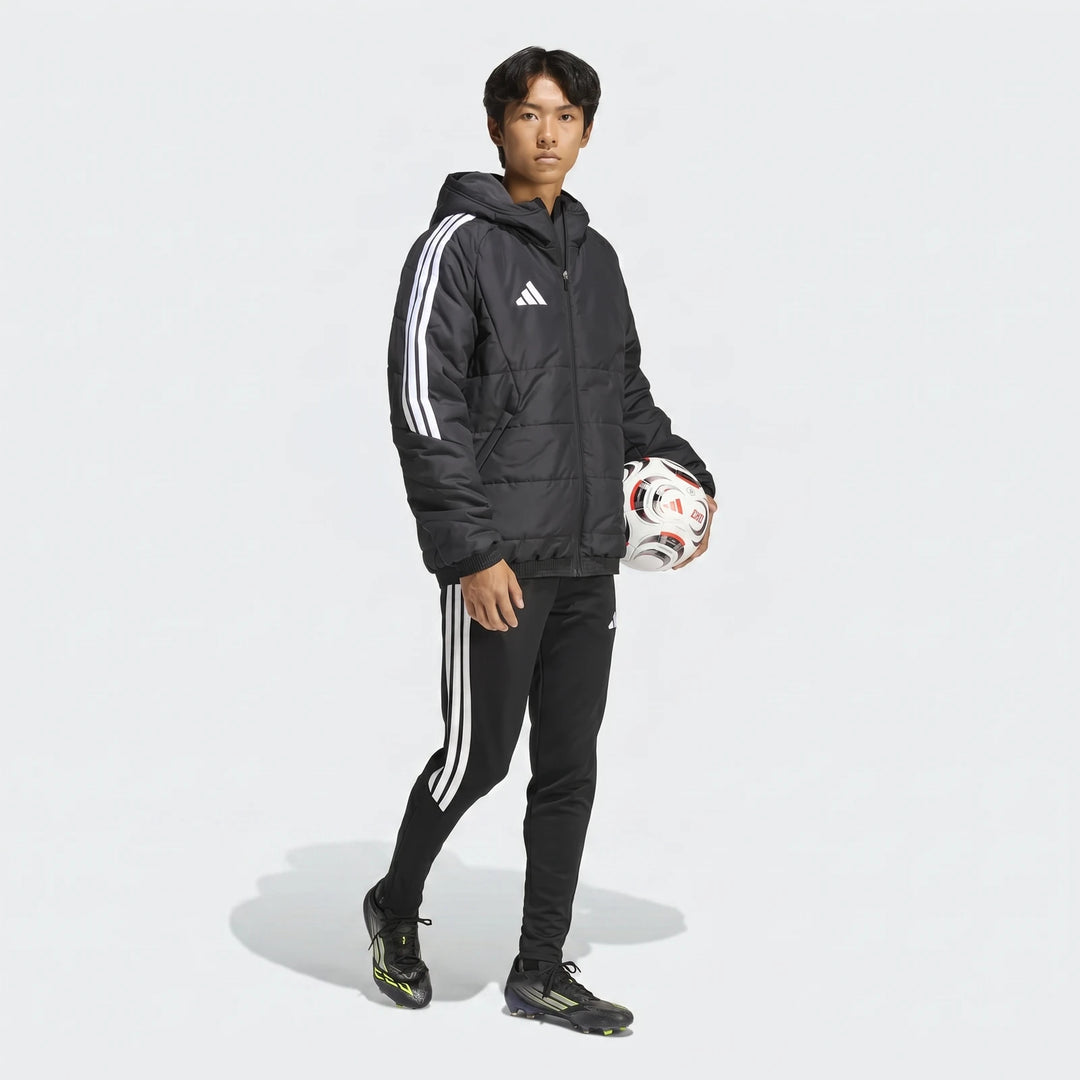 Male model in black Adidas Tiro 26 Windbreaker Jacket and track pants, holding a soccer ball, full body shot.