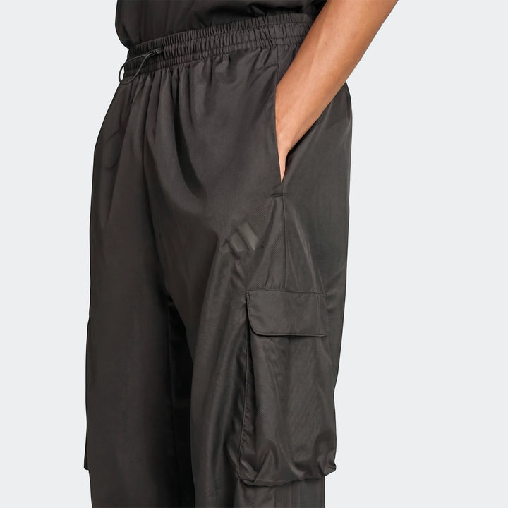 Closeup of black utility woven pants for men, featuring an elastic waistband and a cargo pocket on the side.