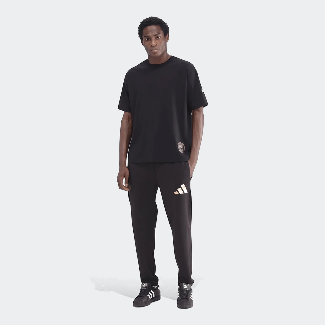 Male model in a black Sportswear Open Hem Single Jersey T-Shirt, matching black sweatpants, and black sneakers, full body