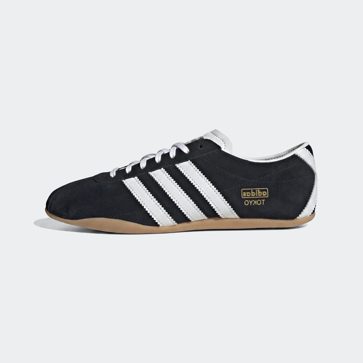 Black suede Adidas Tokyo men's sneakers with white stripes and laces, displayed in a side profile view.