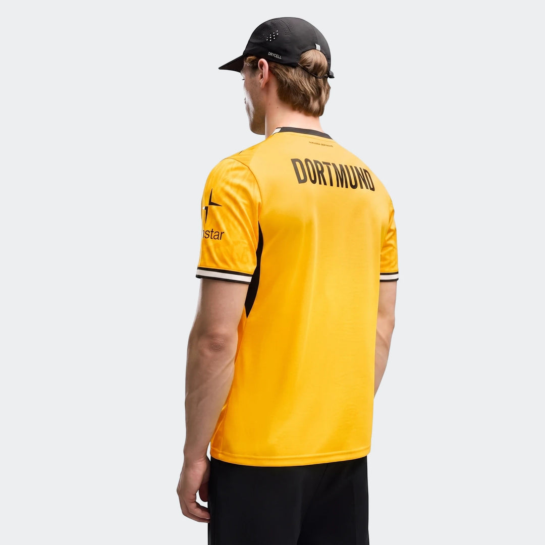 Back view of a man wearing a yellow and black Borussia Dortmund 26/27 Home Jersey and a black cap.