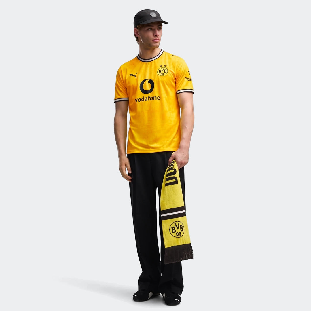 Borussia Dortmund 26/27 Home Jersey for men in yellow and black, worn by a male model holding a team scarf.