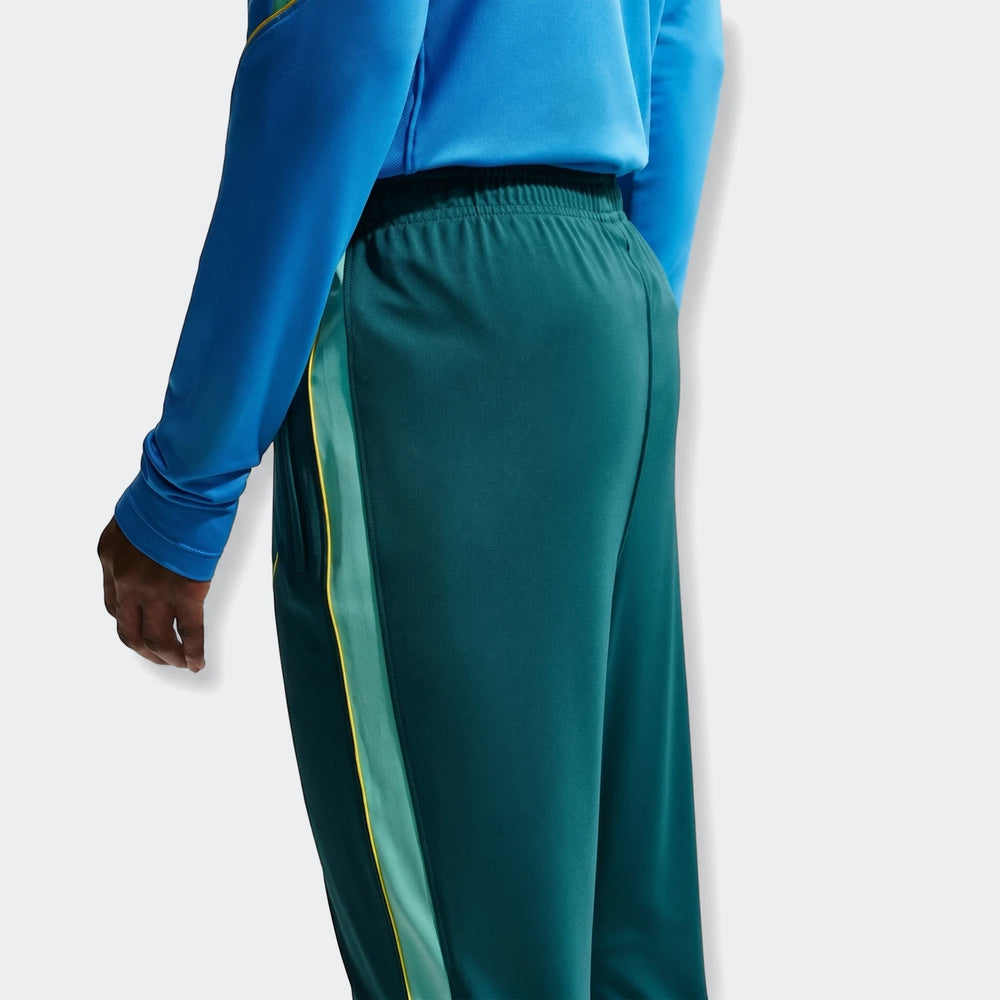 Back view of Brazil Academy Pro Green Men's Nike Dri-Fit Soccer Track Pants with blue top, showing yellow and light green