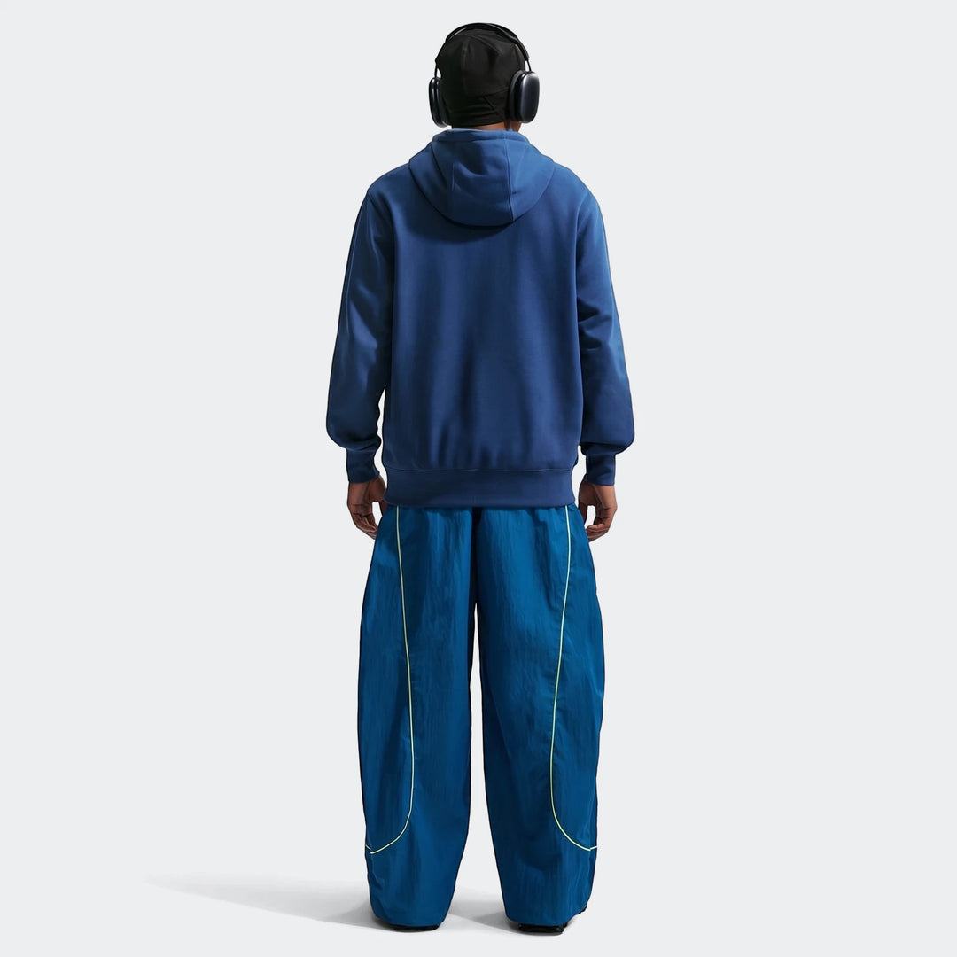 Brazil Club Blue Men's Nike Soccer French Terry Pullover Hoodie, shown from the back, paired with baggy blue track pants.