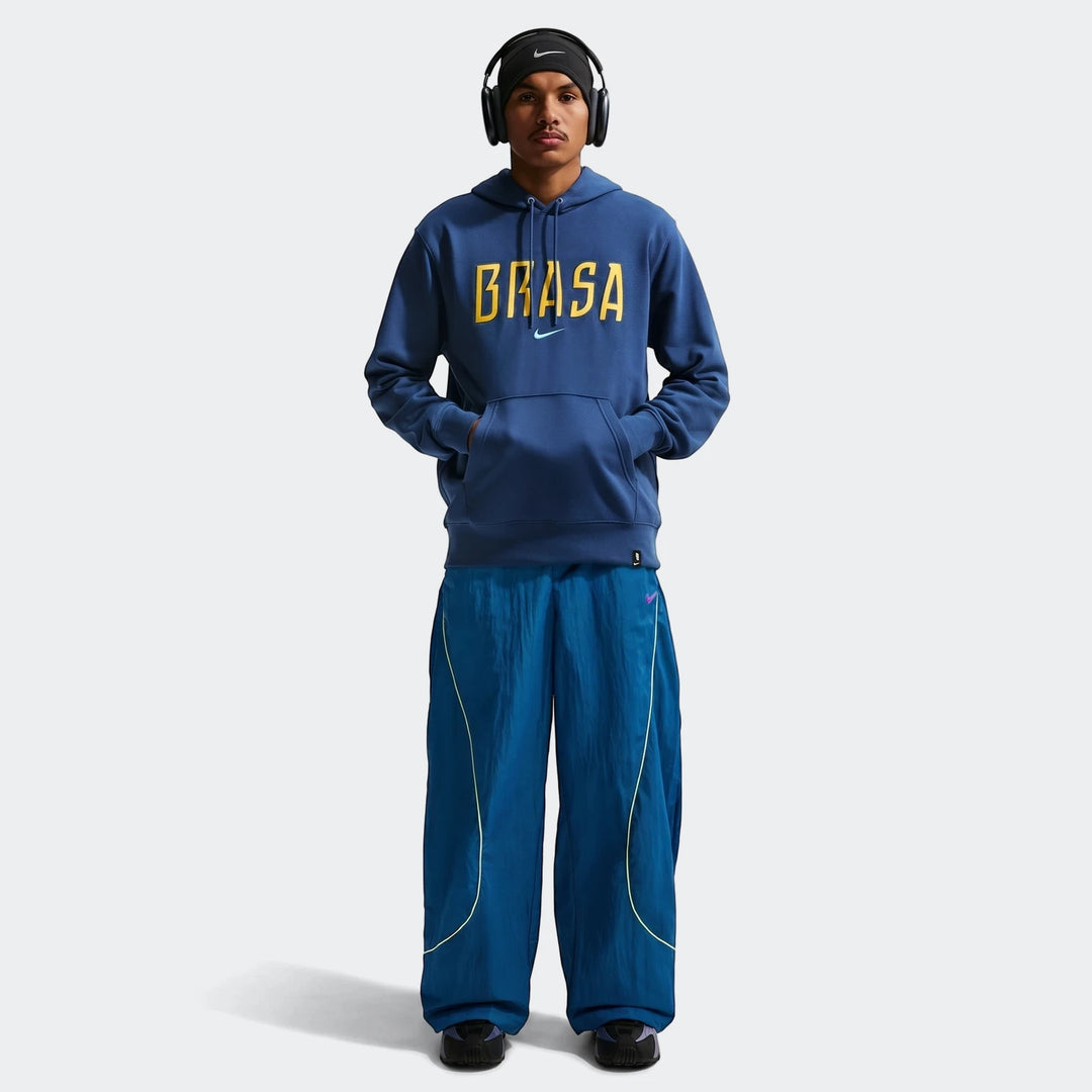 Brazil Club Blue Men's Nike Soccer French Terry Pullover Hoodie worn by a male model. Full body shot featuring blue track