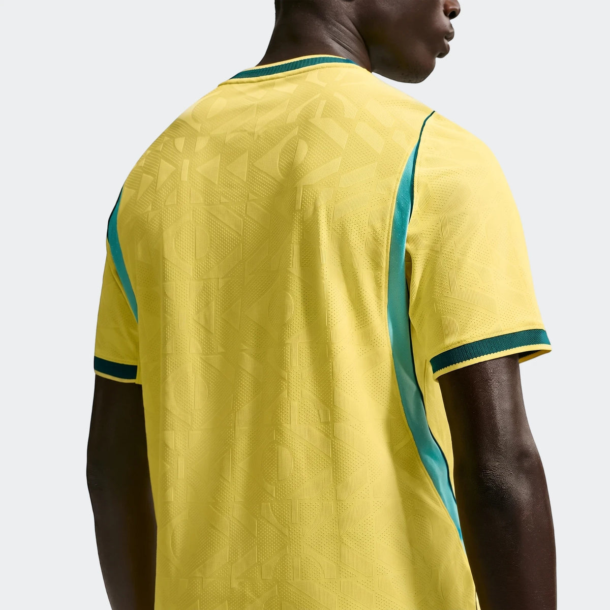 Back view of Brazil National Team 2026 Men's Nike Aero-Fit Home Soccer Jersey in yellow with geometric pattern, teal side